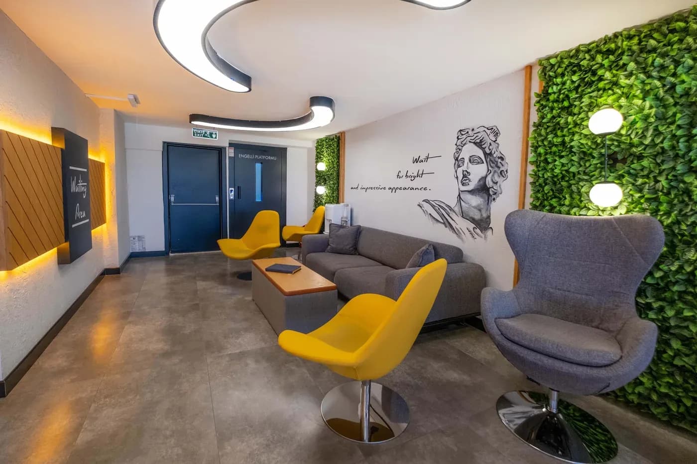 Sarı koltuklu ve yeşil duvarlı bekleme salonu